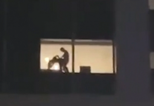 Shocking moment couple were spotted having sex in hotel window in full view of religious festival goers (video)